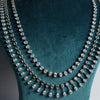 The design showcases a classic tennis-style necklace combined with pear-shaped diamond