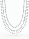 The design showcases a classic tennis-style necklace combined with pear-shaped diamond